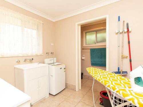 a bathroom with a sink and a washing machine at Wayila in Hawks Nest