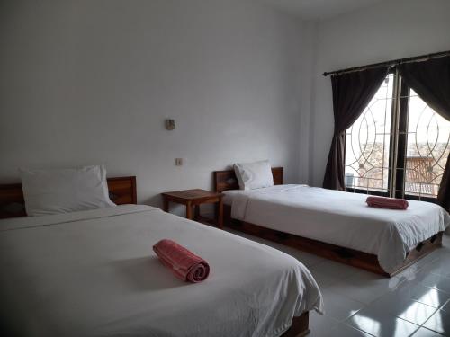 1 dormitorio con 2 camas y un objeto rojo en la cama en Spear Villa, en Bumbang