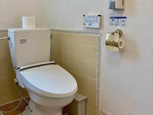 a bathroom with a toilet and a roll of toilet paper at Gallery HARA and guest house in Hara