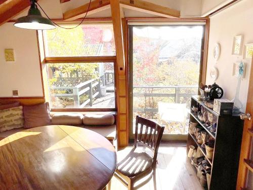 a living room with a wooden table and a large window at Gallery HARA and guest house in Hara