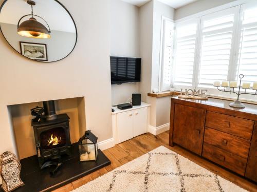 a living room with a fireplace and a mirror at The Willows in Melton Mowbray