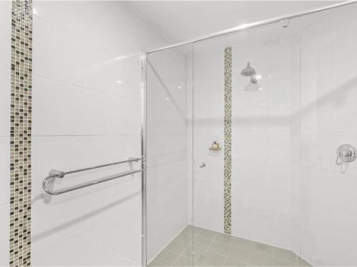 una doccia con una porta in vetro in un bagno di Villa Serene 3, 6-10 Market Street - Surfside Apartments WiFi, water views, Air Con, Pool a Fingal Bay