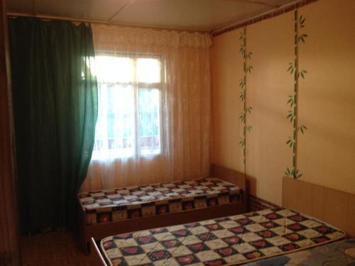 a bedroom with two beds and a window at Tur Service Guest House in Vardane