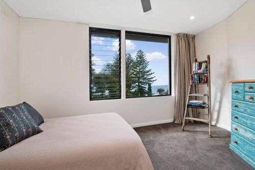 シドニーにあるBronte Beach House with Ocean Viewsのベッドと大きな窓のある寝室