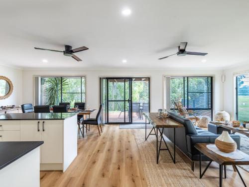 a kitchen and living room with a couch and a table at Villa 121 Horizons in Salamander Bay