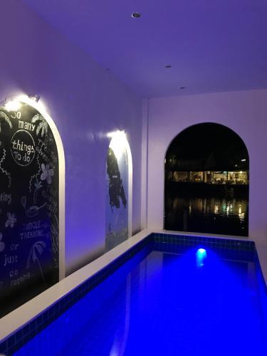 a swimming pool with blue lights in a purple room at Watercolours in Ko Chang