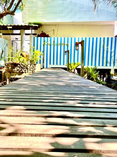 a wooden walkway in front of a blue fence at Watercolours in Ko Chang