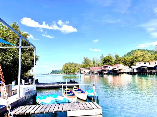 a group of boats docked at a dock on a lake at Watercolours in Ko Chang