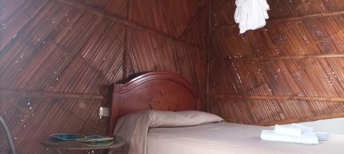 a bedroom with a bed in a straw hut at Hostal Villa Brisa in Ballenita