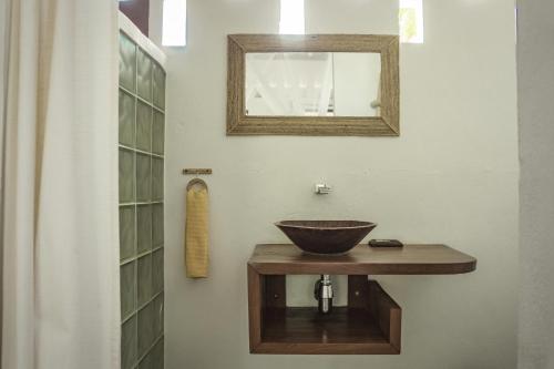 a bathroom with a sink and a mirror on a wall at Chez Senga in Madirokely