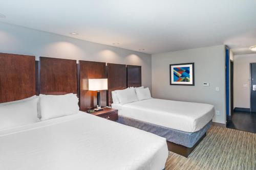 two beds in a hotel room with white sheets at Holiday Inn Express & Suites Austin NW – Lakeway by IHG in Lakeway