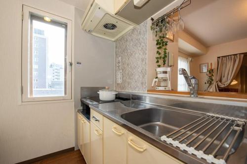 a kitchen with a sink and a window at Rest52 inn in Sapporo