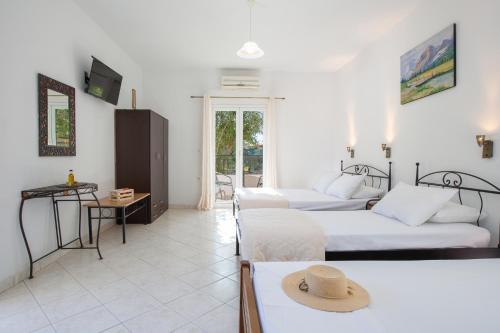 a room with two beds and a table with a hat on it at Spacious Studios Lefkada Mountain View Near Beach in Dhráganon