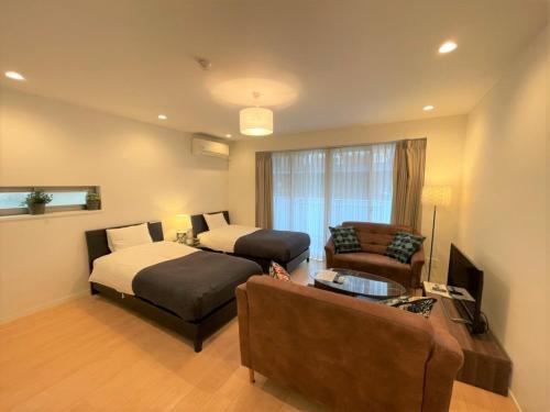 une chambre d'hôtel avec un lit et un canapé dans l'établissement Salon Shibuya - Vacation STAY 78188, à Tokyo