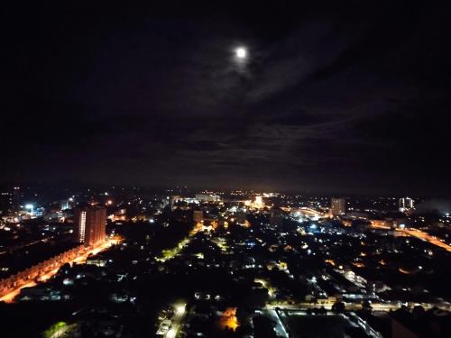 a city at night with the moon in the sky at CMK APARTMEN MUTIARA TOWER 3 BEDROOM KOTA BHARU#Netflix in Kota Bharu
