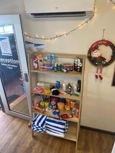 a shelf with food on it in a store at Kennedy Drive Boutique Motel - Close To City Centre & Airport in Tweed Heads