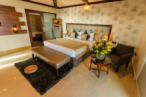 a bedroom with a bed and a couch and a table at Polo Cherrapunjee Resort in Cherrapunji