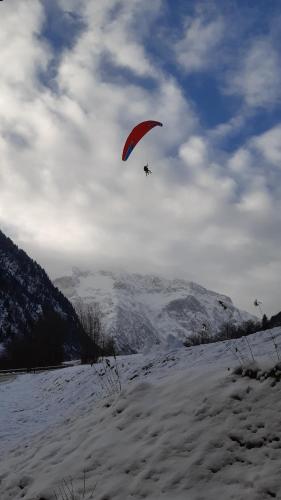 a person flying a kite in a snow covered field at Vénosc-Les 2 Alpes , Rez de jardin in Vénosc