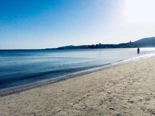 a person standing on a beach near the water at Alghero Old Town Gem - Emerald in Alghero
