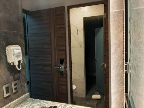 a bathroom with a mirror and a toilet and a door at Amarterra Hotel Boutique in Mexico City