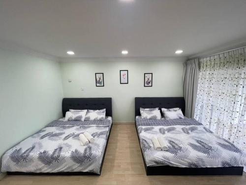 2 nebeneinander sitzende Betten in einem Schlafzimmer in der Unterkunft EquatorialHillResort SunsetView 10Min Popular FARM in Brinchang