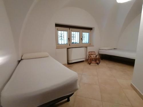 a small room with two beds and a window at Casa Palumbo in San Donato