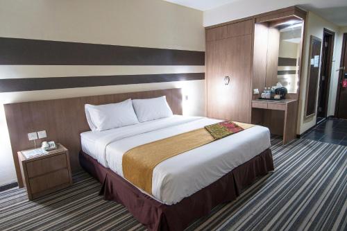 ジョホールバルにあるGrand Sentosa Hotel Johor Bahruのホテルルーム内のベッドルーム1室(大型ベッド1台付)