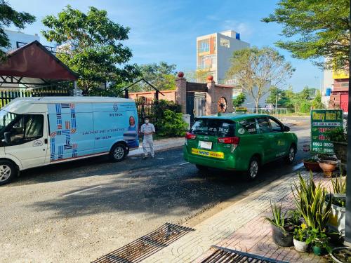 a van and a truck parked next to a house at Cherry Hotel Bến Lức in Bến Lức