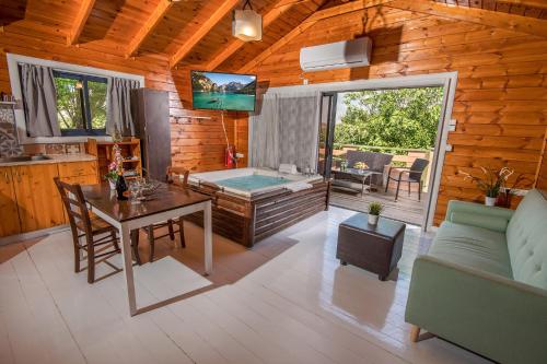 a living room with a dining table and a tub at SOL Suite In The Village in Shomera