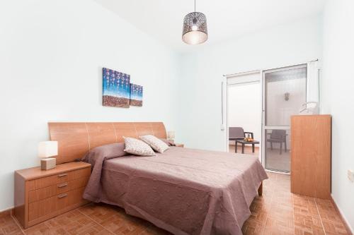 1 dormitorio con 1 cama, vestidor y ventana en Home2Book Charming House El Cotillo, en Cotillo