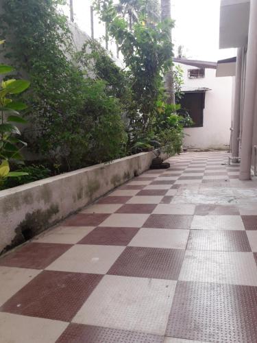 un couloir vide avec un sol en damier dans un bâtiment dans l'établissement Sudha Kutir Puri, à Purî