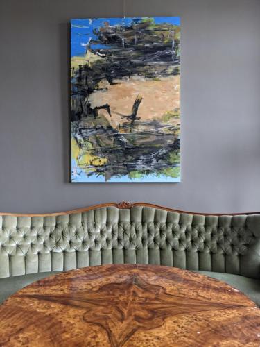 a living room with a table and a painting on the wall at Gut Pohnstorf in Alt Sührkow