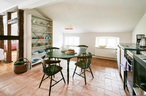 a kitchen with a table and chairs in a room at Gut Pohnstorf in Alt Sührkow