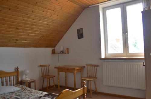 a bedroom with a bed and a table and a window at Dom pod Czarnym Bocianem in Tykocin