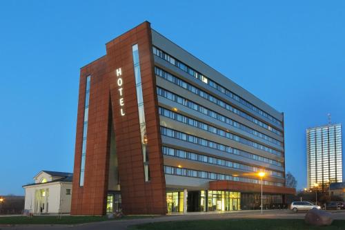 a tall red brick building with a sign on it at Aurora Hotel Klaipeda in Klaipėda