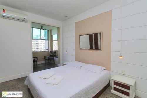 una camera bianca con un letto e una sedia di Bom studio perto da praia em Copacabana a Rio de Janeiro