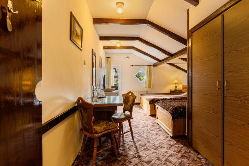 - une chambre avec un lit, un bureau et une chaise dans l'établissement Pension Casa Bradul, à Predeal