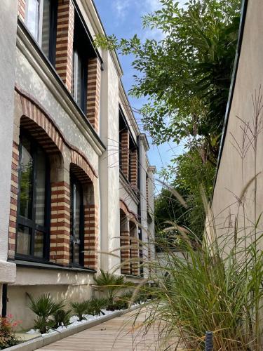 a building with windows and plants on the side of it at Maison d'hotes L'atelier du Charmois in Vandoeuvre-lès-Nancy