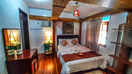 a bedroom with a bed and a table and a desk at Ananda Resort in Panglao