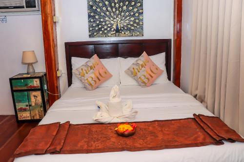 a bed with a towel and a bowl of fruit on it at Ananda Resort in Panglao