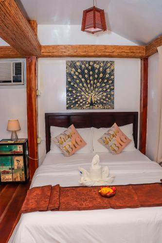 a bedroom with a bed with white sheets and a candle on it at Ananda Resort in Panglao