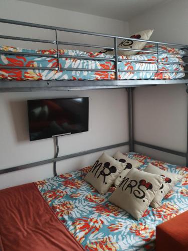 a bed in a room with two bunk beds at chez christian&astrid Next to Disneyland Paris in Penchard