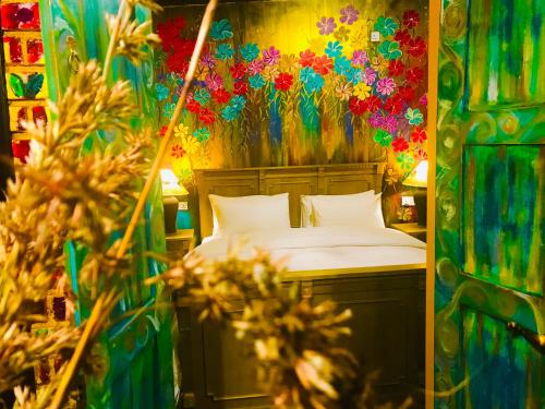 una camera da letto con un letto con fiori sul muro di Serendipity Lake Artistic Bungalow by Heidis Home a Nuwara Eliya