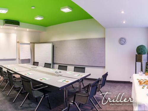 a conference room with a long table and chairs at Hotel Am Triller - Hotel & Serviced Apartments in Saarbrücken
