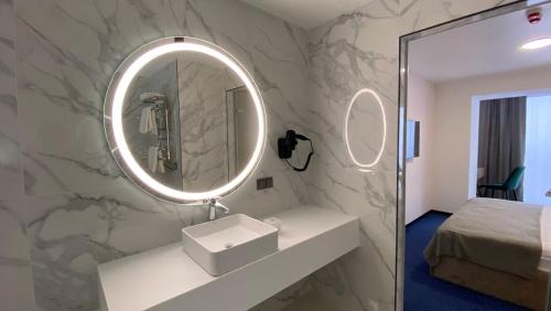 ein Badezimmer mit einem Waschbecken und einem Spiegel an der Wand in der Unterkunft Optima Collection Kamianske in Kamjanske