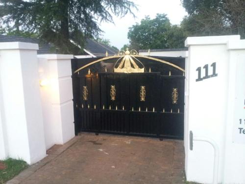 an entrance to a black gate in a driveway at The Royal Princess B&B on Malibongwe Drive in Johannesburg