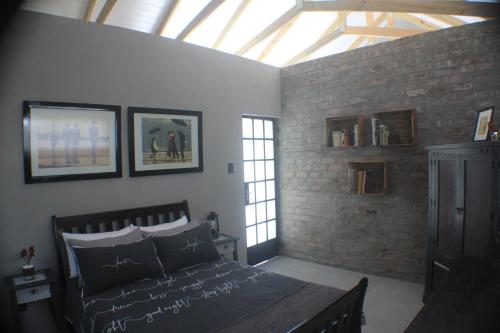 a bedroom with a bed in a room with a skylight at Pecan Tree Cottage in Montagu