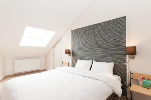 um quarto com uma grande cama branca e uma cabeceira preta em Smartflats Design - Opera em Liège