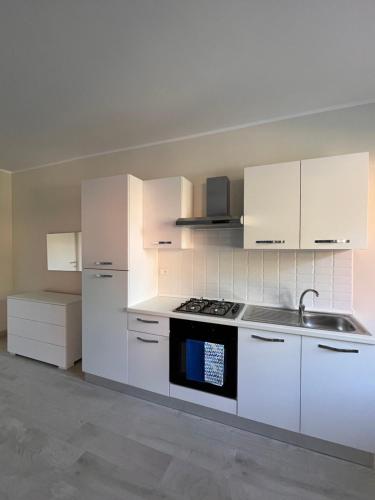 a kitchen with white cabinets and a stove top oven at Casa Cost in Vetralla