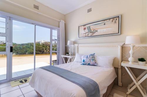 una camera da letto con un letto e una grande finestra di Clifton Cottage a Kei Mouth